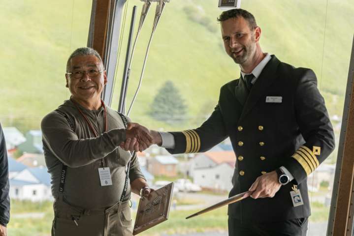 Alutiiq Tribe of Old Harbor Chief Jeffrey Peterson presents a ceremonial paddle to Captain Bram Olof of the MS Roald Amundsen during HX's inaugural visit to Old Harbor.