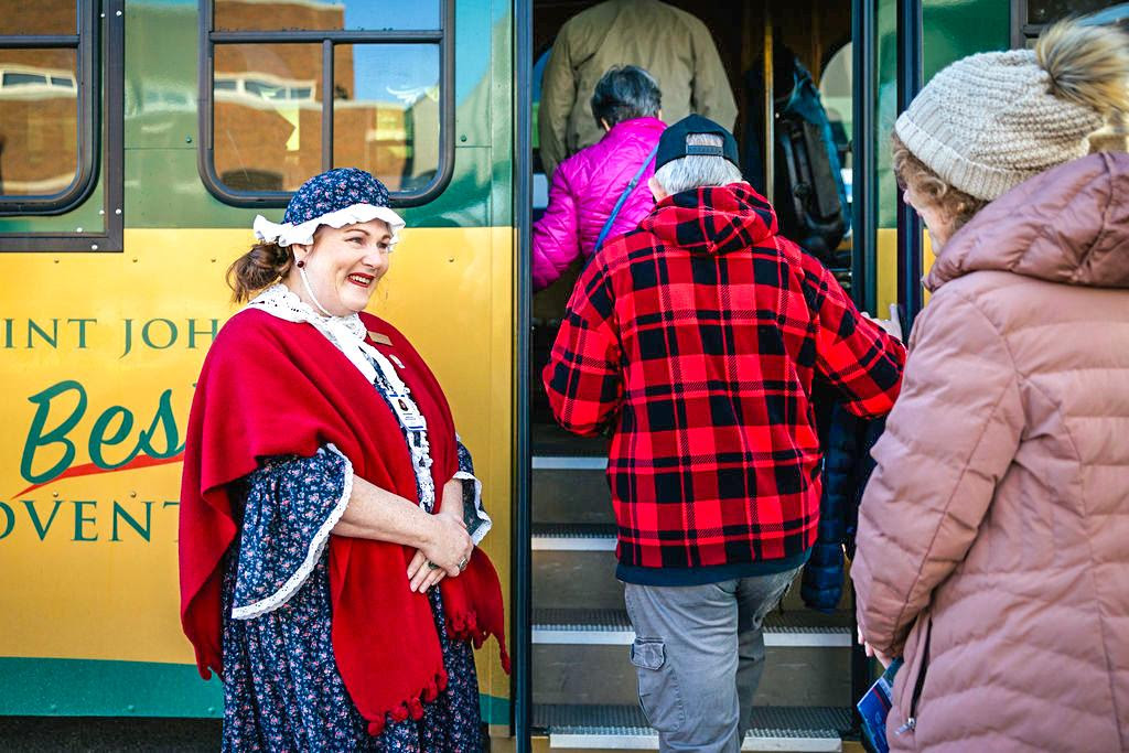 A costumed guide welcomes visitors in Saint John, demonstrating the storytelling and guest engagement skills central to Aquila’s training programs.